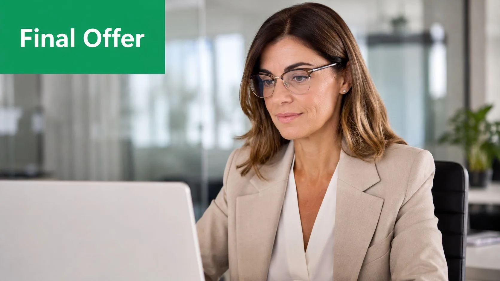 Eine professionelle Frau in einem beigen Blazer am Laptop, die eine geschäftliche E-Mail zur Hintergrundüberprüfung darstellt.