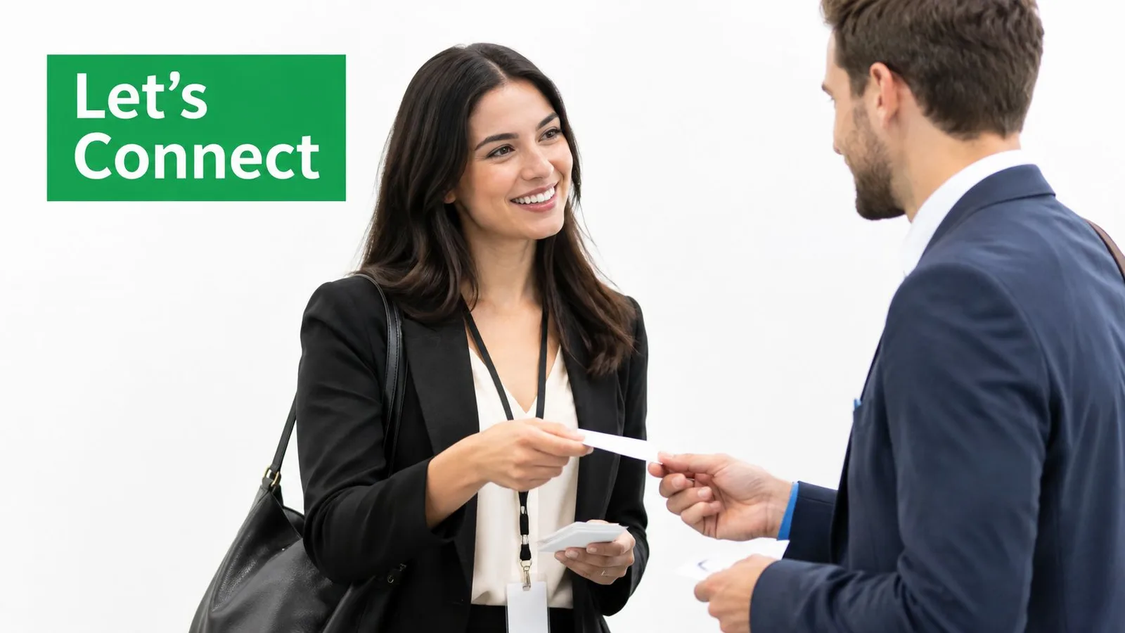 A professional woman in a business suit smiling while exchanging business cards with a male colleague.
